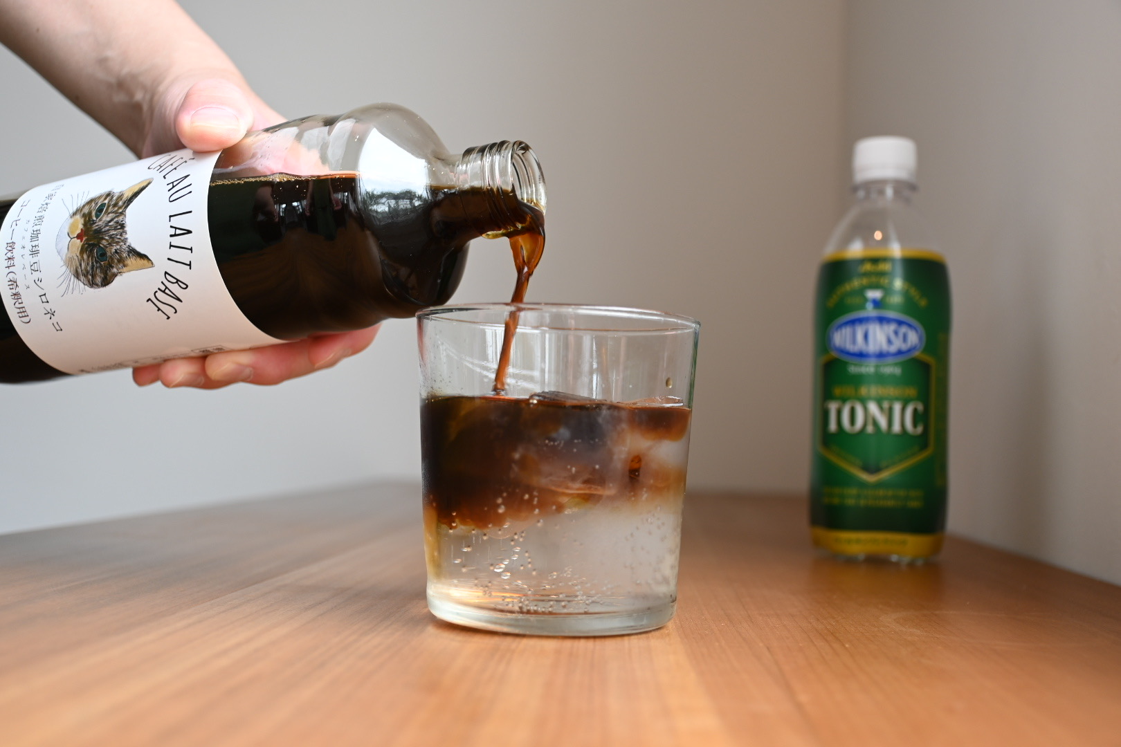 氷の上に向かってカフェオレベースを静かに注ぎ入れる様子